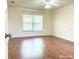 Spacious bedroom featuring a ceiling fan, window with blinds, and well-maintained hardwood flooring at 3095 Coronet Ct, Spring Hill, FL 34609