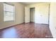 A cozy bedroom features hardwood floors, a closet, and a view to the outside at 3095 Coronet Ct, Spring Hill, FL 34609