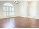 Bright living room showcasing elegant window shutters, chandelier, and hardwood floors at 3095 Coronet Ct, Spring Hill, FL 34609