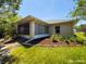 A sunroom on the back of the house is surrounded by green grass and bushes at 3095 Coronet Ct, Spring Hill, FL 34609