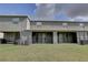 Backyard with covered patio, sliding glass doors, lawn, and grey exterior elevation at 33062 Frosted Clover Way, Wesley Chapel, FL 33545