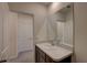 Bright bathroom features a single sink vanity, large mirror, and an entrance to a hallway at 33062 Frosted Clover Way, Wesley Chapel, FL 33545