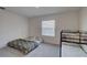 Bedroom features one bed and a bunk bed near a window and door at 33062 Frosted Clover Way, Wesley Chapel, FL 33545