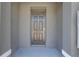 A simple, dark-colored front door on a covered porch offers security and style, inviting you into the home at 33062 Frosted Clover Way, Wesley Chapel, FL 33545