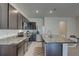 Modern kitchen with an island, granite countertops, stainless steel appliances, and tile flooring, perfect for cooking at 33062 Frosted Clover Way, Wesley Chapel, FL 33545