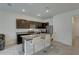 Open kitchen with granite countertops, dark wood cabinets, and stainless steel appliances provides a modern culinary space at 33062 Frosted Clover Way, Wesley Chapel, FL 33545
