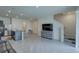 Open-concept living space with tile flooring, island seating and stainless steel appliances at 33062 Frosted Clover Way, Wesley Chapel, FL 33545