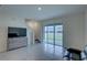 Spacious living room featuring tile floors, backyard access, and stairs to the second floor at 33062 Frosted Clover Way, Wesley Chapel, FL 33545