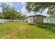 Spacious backyard featuring a lush lawn, mature trees, and a white fence at 3418 W Bay Ave, Tampa, FL 33611