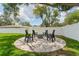 Backyard fire pit with stylish Adirondack chairs on a stone-paved patio, perfect for outdoor gatherings at 3418 W Bay Ave, Tampa, FL 33611