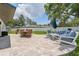 Spacious backyard featuring a stone patio with a dining table and a comfortable seating area at 3418 W Bay Ave, Tampa, FL 33611