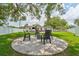 Backyard featuring a fire pit with chairs, lush green grass, and a partial view of the home at 3418 W Bay Ave, Tampa, FL 33611