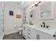 Modern bathroom with double sinks, white cabinetry, and a glass-enclosed shower at 3418 W Bay Ave, Tampa, FL 33611