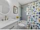 Bright bathroom with a vanity, a tub with shower, and a fish-themed curtain at 3418 W Bay Ave, Tampa, FL 33611