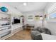 Bright bedroom with light wood floors, a gray chair, white built-in shelves, and a ceiling fan at 3418 W Bay Ave, Tampa, FL 33611
