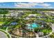 Aerial view of community pool, playground, sports courts and pond surrounded by lush tropical landscaping at 3611 Natural Trace St, Plant City, FL 33565