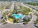 Aerial view of community pool, playground, sports courts and residences in a well manicured tropical community at 3611 Natural Trace St, Plant City, FL 33565