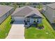 Aerial view of a well-maintained home with lush landscaping, spacious driveway, and fenced backyard at 3611 Natural Trace St, Plant City, FL 33565