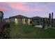 Twilight view of backyard, featuring covered patio and a lush lawn, great for entertaining at 3611 Natural Trace St, Plant City, FL 33565
