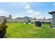 Large fenced backyard features a well-manicured lawn, stone patio and walkway, and a barbecue area at 3611 Natural Trace St, Plant City, FL 33565
