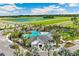 Aerial view of the community pool with palm trees and lake in the background at 3611 Natural Trace St, Plant City, FL 33565