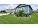 Charming home exterior with a well-manicured lawn, blooming flowers, and lush tropical landscaping at 3611 Natural Trace St, Plant City, FL 33565