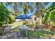 Shaded backyard with dining table and privacy fence plus lots of mature trees and tropical plants at 3626 S Hesperides St, Tampa, FL 33629