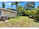 Backyard showing mature landscaping, side of the house, and air conditioning unit at 3626 S Hesperides St, Tampa, FL 33629