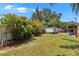 A backyard with a storage shed surrounded by grass, trees, and a white fence at 3626 S Hesperides St, Tampa, FL 33629