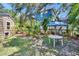 Lush backyard featuring a dining table with an umbrella, and privacy fence and tropical landscaping at 3626 S Hesperides St, Tampa, FL 33629