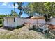 Backyard with a white storage shed, a round table and seating under a tiki umbrella at 3626 S Hesperides St, Tampa, FL 33629