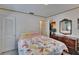 Bedroom with floral bedding, mirror and natural light, creating a peaceful and cozy atmosphere at 3626 S Hesperides St, Tampa, FL 33629