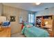 Comfortable bedroom featuring a single bed, wooden shelving, and warm natural light at 3626 S Hesperides St, Tampa, FL 33629