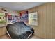 Cozy bedroom featuring simple decor, a large window with natural light, and paneled walls at 3626 S Hesperides St, Tampa, FL 33629