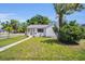 Cozy single-story home with green lawn, walkway, and mature trees on a sunny day at 4000 Grove S St, St Petersburg, FL 33705