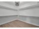 This is a walk-in closet with wood floors and neutral walls with shelves for storage at 4000 Grove S St, St Petersburg, FL 33705