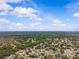 Expansive aerial view of a neighborhood surrounded by lush greenery under a bright, partly cloudy sky at 4120 Tyndale Dr, Brandon, FL 33511