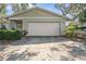 Close-up view of a home's two-car garage and front entrance surrounded by greenery at 4120 Tyndale Dr, Brandon, FL 33511
