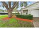 Charming home featuring a well-manicured lawn, mature tree, and colorful mulch landscaping at 4120 Tyndale Dr, Brandon, FL 33511