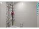 Shower with adjustable shower head, tile wall and toiletries on a rack at 4120 Tyndale Dr, Brandon, FL 33511