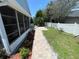 Inviting backyard featuring a brick pathway, manicured lawn, and privacy fence, creating a serene outdoor retreat at 4214 Foxboro Dr, New Port Richey, FL 34653