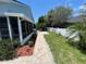 Landscaped backyard featuring a brick pathway, lawn, and white fence providing a private and serene outdoor space at 4214 Foxboro Dr, New Port Richey, FL 34653