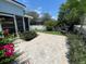 Charming backyard with a brick patio, a pair of chairs, and lush landscaping, creating a delightful outdoor oasis at 4214 Foxboro Dr, New Port Richey, FL 34653