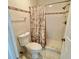 Bathroom featuring a toilet, tile floors, and shower with curtain enclosure at 4214 Foxboro Dr, New Port Richey, FL 34653