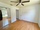 Bedroom with hardwood floors, window view, and mirrored closet at 4214 Foxboro Dr, New Port Richey, FL 34653