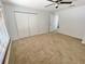 Carpeted bedroom featuring a ceiling fan and large closet with ample storage at 4214 Foxboro Dr, New Port Richey, FL 34653