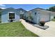 Welcoming light blue single-Gathering home with manicured front yard, landscaping and an attached two-car garage at 4214 Foxboro Dr, New Port Richey, FL 34653