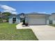 Inviting light blue single-Gathering home featuring a spacious driveway leading to an attached two-car garage at 4214 Foxboro Dr, New Port Richey, FL 34653