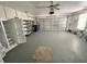 Spacious garage featuring a refrigerator, shelving, and a large roll-up door for convenient access and storage at 4214 Foxboro Dr, New Port Richey, FL 34653