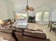 Bright living room area with comfortable leather seating, tile flooring, and a sliding glass door to the porch at 4214 Foxboro Dr, New Port Richey, FL 34653